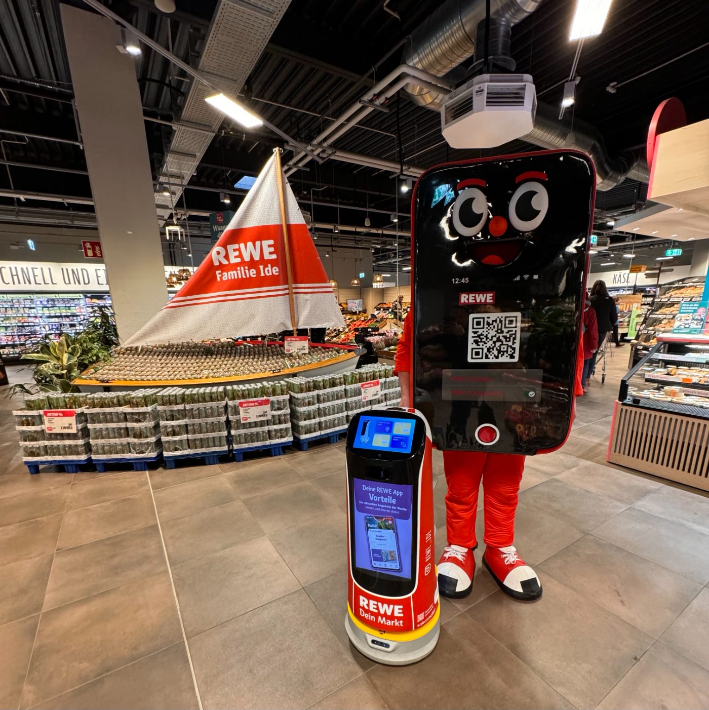 KettyBot Pro begrüßt Kunden gemeinsam mit dem REWE-Maskottchen