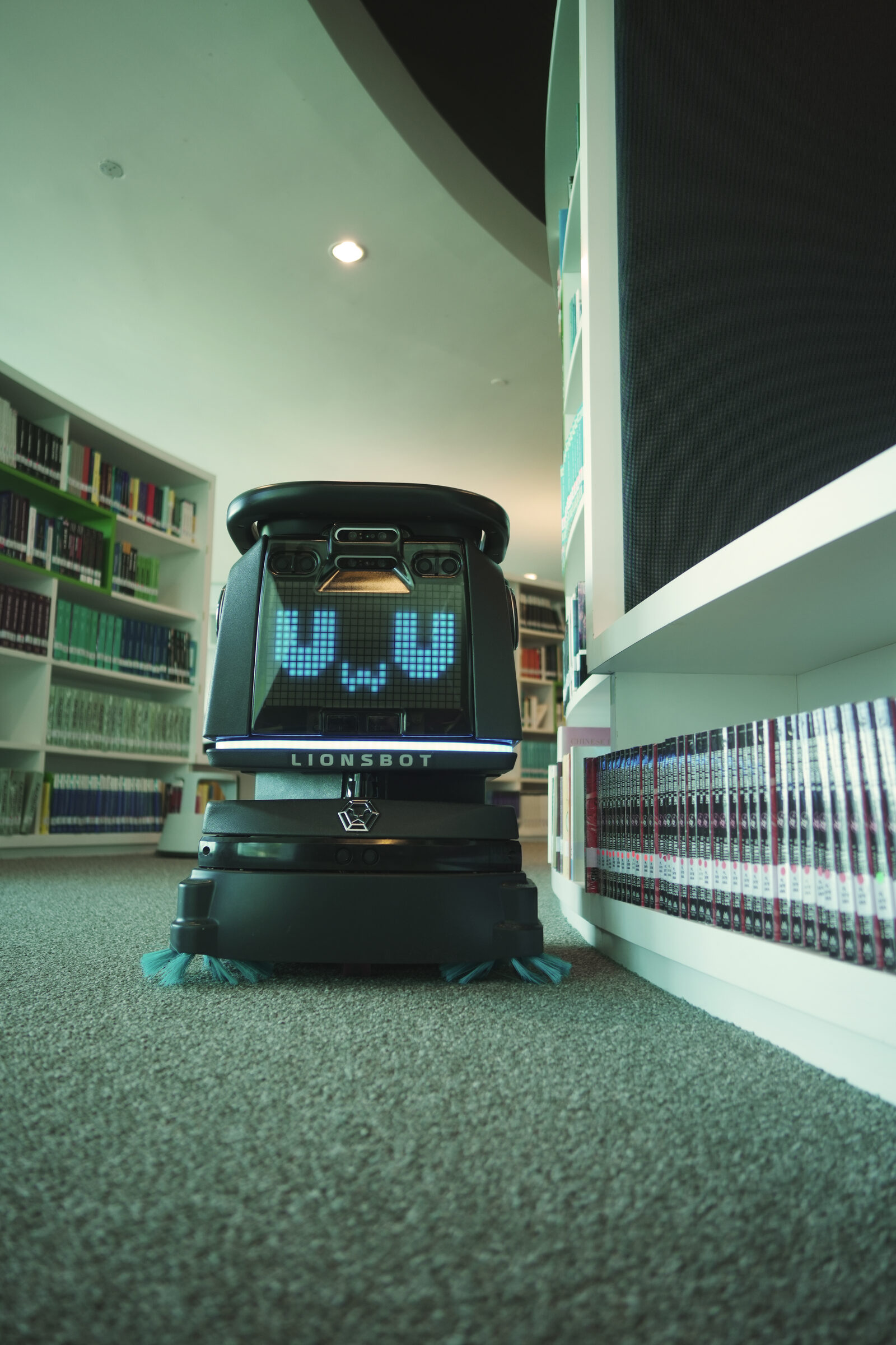 LionsBot R3 Vac reinigt leise zwischen Bibliotheksregalen