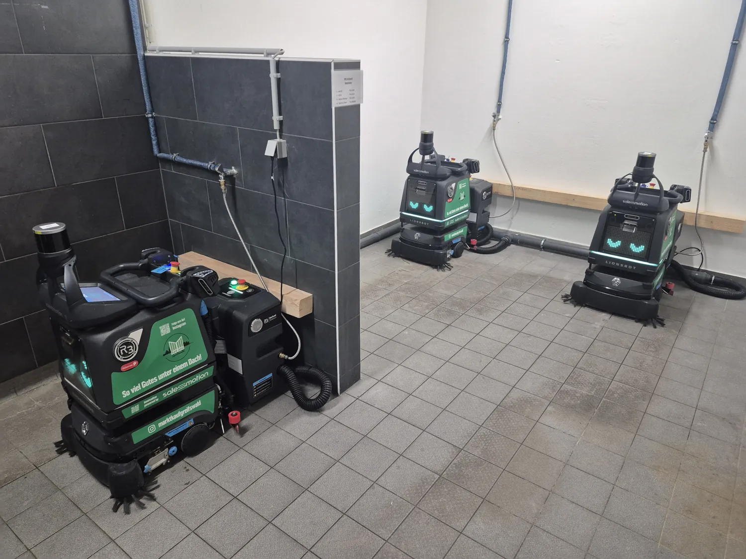 Three LionsBot R3 Scrub Pro robots as a cleaning fleet in a hypermarket